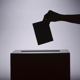 Image of vote being put into a box