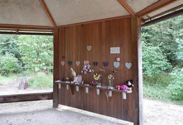 Wooden shelter with flowers and heart shaped plaques