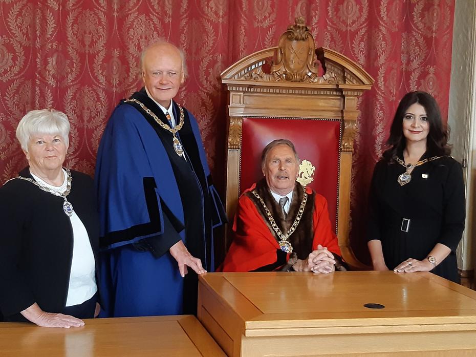 The Deputy Mayoress and the Deputy Mayor are standing on the left of the Mayor who is sitting down. On the right of the Mayor is the Mayoress.