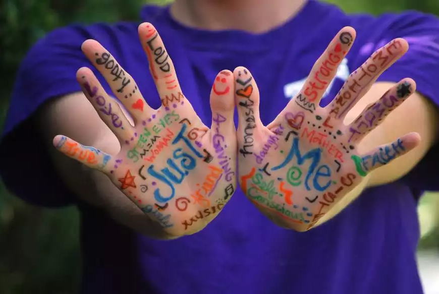 hands with multicoloured writing on